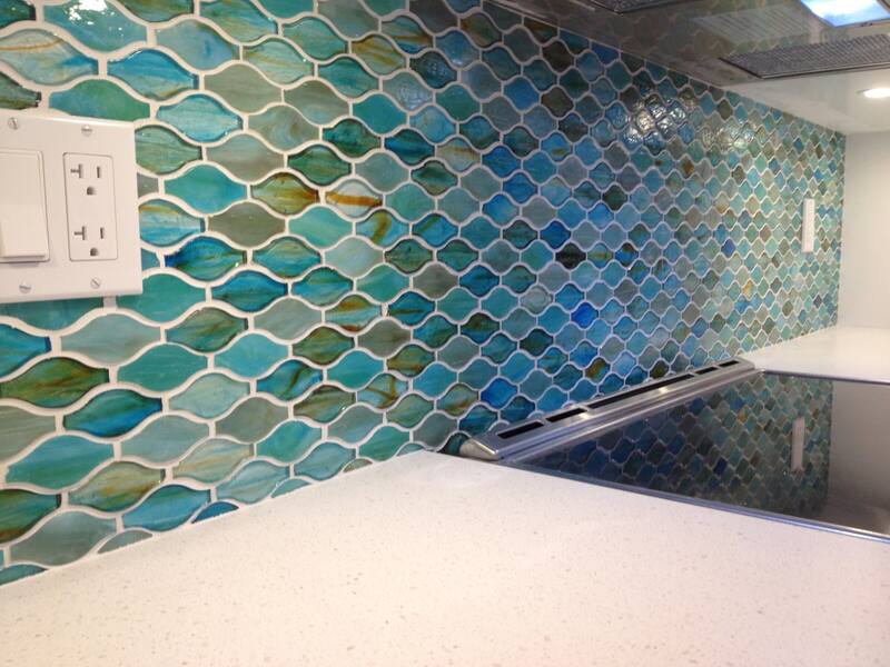 Teal and blue mosaic tile backsplash behind a cooktop
