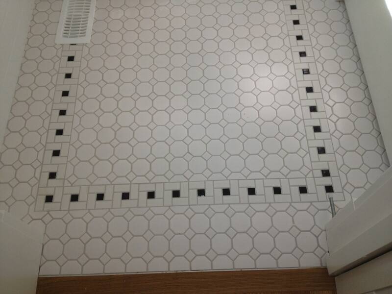 White octagon mosaic bathroom floor with a black square dot border