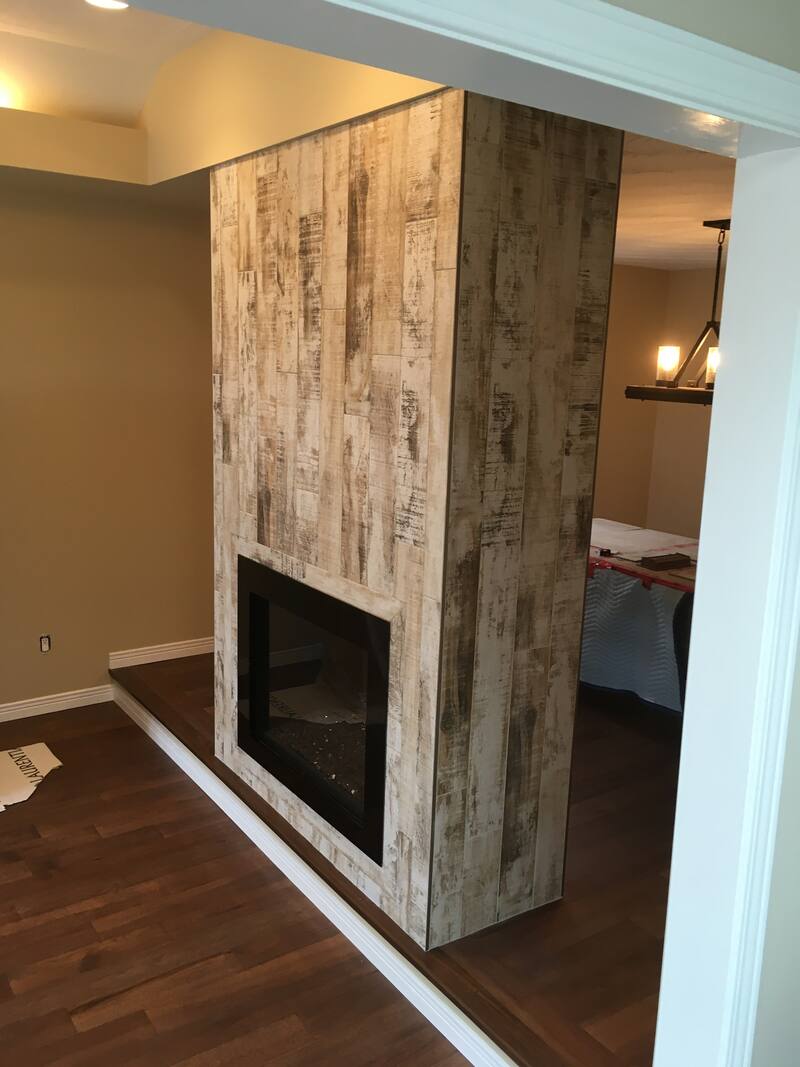Fireplace surround and chimney wall covered in weathered wood-look tile